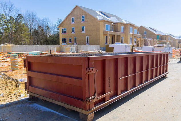 A construction home renovation building in White Plains, NY, has a rubbish removal container.